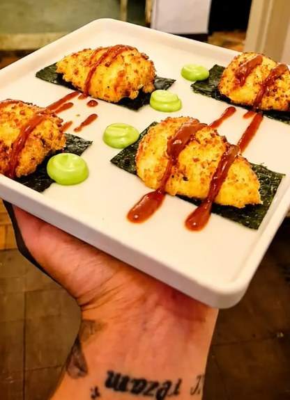 Goxinhas douradas sobre folhas de nori, com catchup de missô e maionese de wasabi, em prato branco
